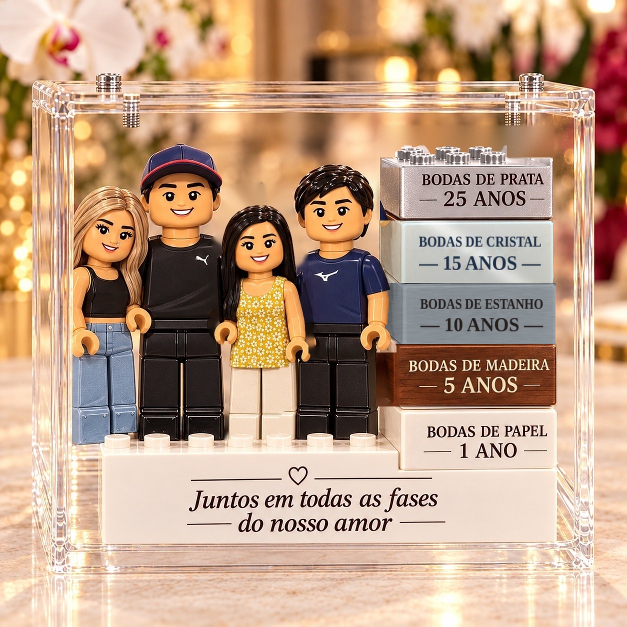 O mesmo casal em blocos de montar, 25 anos depois, com a filha e o filho, ao lado da pilha de blocos das bodas de papel, madeira, estanho, cristal e prata, numa vitrine de acrílico